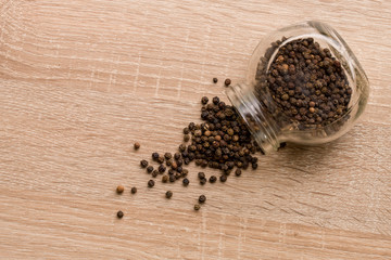  Black Pepper Peas Scattered On The Table From A Glass Jar. Close Up. Macro. Top View.