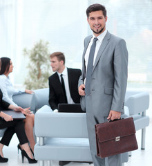 Sticker - confident businessman with briefcase standing in the lobby of the office.