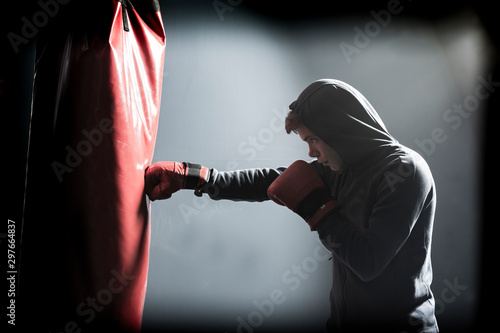 The young man workout a kick on the punching bag Tableau sur Toile