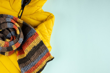 Yellow kids winter jacket composition on blue background.