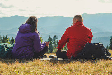 Girl and man hikers in mountains. Travel backpacks and clothing. Campaign. Ukrainian Carpathian Mountains. Traveling in Ukraine.