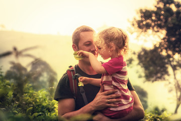 Happy father embracing child daughter outdoors with sunlight in the mountains during vacation as family travelling lifestyle  