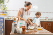 © selugallego - A woman and a child cooking together.