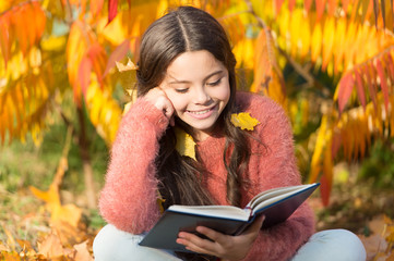 Her hobby is reading. Cute small child reading book on autumn day. Adorable little girl enjoy English literature. Childrens literature. Literature education. Childhood in literature