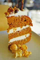 Wall Mural - A slice of carrot cake on a plate with white creamed frosting