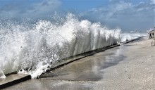 Large Wave Is Crashing Into Beach Wall During A Stormy Day In A St.Pete Beach N Florida During Nestor Showing Rising Sea Levels Due To GLobal Warning Threaten Beach Goers.