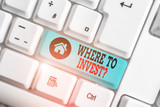 Fototapeta  - Text sign showing Where To Invest Question. Business photo text asking about where put money into financial schemes or shares White pc keyboard with empty note paper above white background key copy