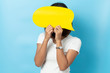 © suriya - Portrait of young girl holding a empty yellow speech bubble isolated on blue background
