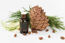 Isolate, Composition,glass Bottle With Oil, Pine Cone, Pine Nuts And Cedar Branch On A White Background