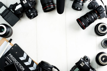 Camping or adventure trip scenery concept. Backpack, boots, belt, thermos and camera on wooden background captured from above (flat lay). Layout with free text (copy) space.