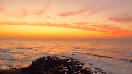 Orange sunrise over the fishing rocks at Ballito.