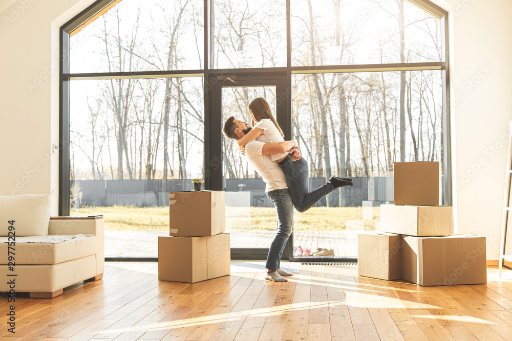 young couple moves to a new home. the family carries boxes of things after buying a home.
