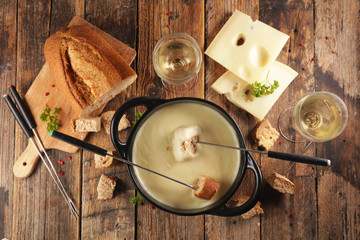 Wall Mural - cheese fondue with wine and bread, top view