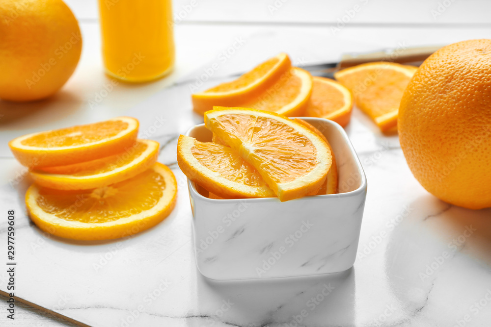 Bowl with orange slices on table