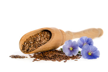 Wall Mural - Flax seeds in the wooden scoop and  beauty flowers isolated on white background.