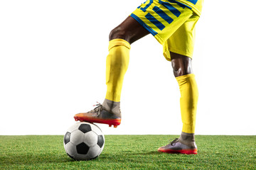 Wall Mural - Professional african-american football or soccer player of yellow team in motion isolated on white studio background. Fit man in action, excitement, emotional moment. Concept of movement at gameplay.