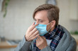 © zinkevych - Blue-eyed man wearing mask while having infection
