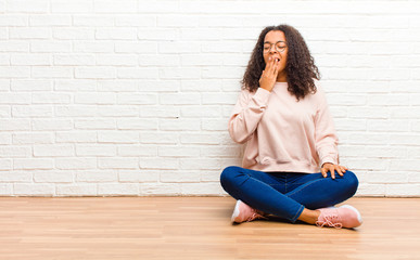 young african american black woman yawning lazily early in the morning, waking and looking sleepy, tired and bored