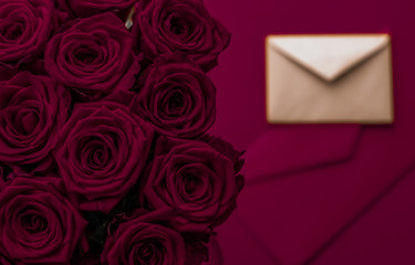 Wall Mural - Love letter and flowers delivery on Valentines Day, luxury bouquet of roses and card on maroon background for romantic holiday design