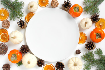 Empty white plate with festive decoration for autumn or winter holidays: Christmas, Thanksgiving, New year