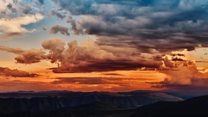 Wall Mural - dramatic light through the clouds against the backdrop of an exciting, vibrant stormy sky at sunset,