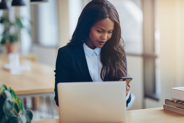 Smiling African American businesswoman using her cellphone at wo