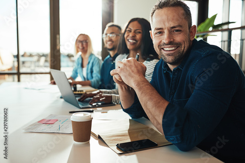 Fotomural Smiling mature businessman sitting with colleagues in an office