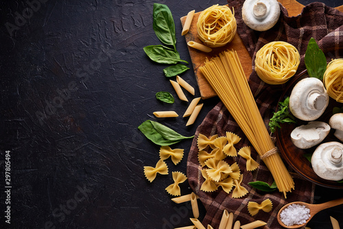 Cuadros en Lienzo ingredients for cooking traditional pasta with mushrooms on dark stone backgroun