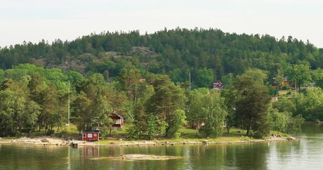 Wall Mural - Many Red Swedish Wooden Sauna Logs Cabins Houses On Island Coast In Summer Cloudy Day. 4K