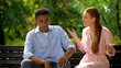 © motortion - Multiethnic couple arguing sitting on bench in park, jealousy, misunderstanding