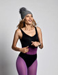 © Dmitry Lobanov - Portrait of happy smiling young sporty woman in purple sports wear and gray winter hat with furry pompon running jogging