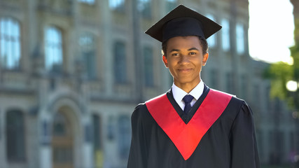 Wall Mural - Happy male student smiling on camera, achievement, graduation day celebration