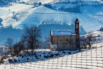 Wall Mural - Parish church on snowy hill in Italy.