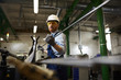 © AnnaStills - Manual worker in protective workwear and glasses wearing gloves holding iron pipe while working in the factory