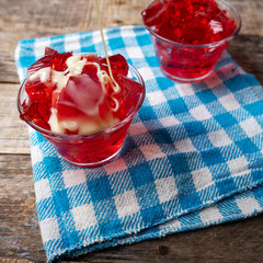 Red jelly with condensed milk on wooden background