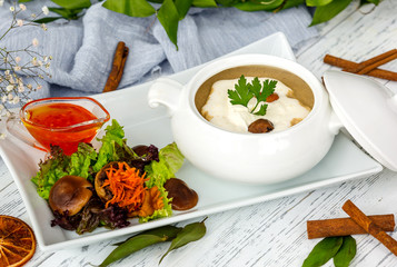 Wall Mural - mushroom soup in ceramic serving ware served with salad and sauce