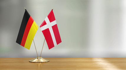 Wall Mural - Danish and German flag pair on a desk over defocused background 