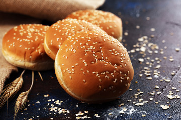 Fresh homemade burger buns with sesame on dark background