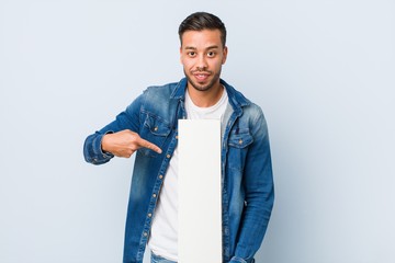 Wall Mural - Young south-asian man holding a white placard.