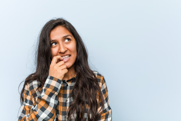 Wall Mural - Young cool indian woman relaxed thinking about something looking at a copy space.