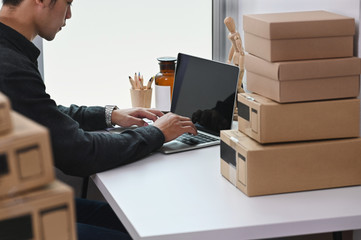 Cropped shot business owner using laptop with receive and checking online purchase shopping order.