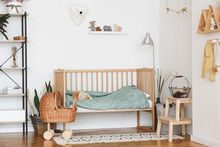 Baby Bedroom Interior With Cozy Wooden Bed And Wicker Stroller
