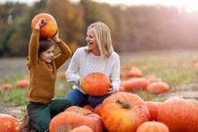 Mother And Son In Pumpkin Patch Field