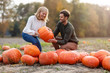 © pikselstock - Happy young couple in pumpkin patch field