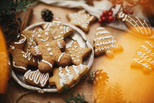 Merry Christmas. Festive Gingerbread Cookies With Anise, Cinnamon, Pine Cones, Cedar Branches And Golden Lights Bokeh On Rustic Table. Atmospheric Image. Seasons Greetings