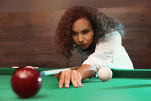 Young African-American Woman Playing Russian Billiard Indoors