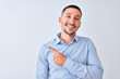 © Krakenimages.com - Young handsome business man standing over isolated background with a big smile on face, pointing with hand and finger to the side looking at the camera.