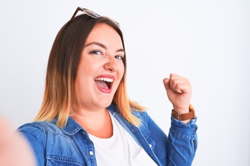 Young beautiful woman wearing denim shirt  standing over isolated white background screaming proud and celebrating victory and success very excited, cheering emotion