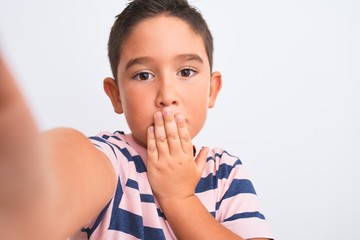 Canvas Print - Beautiful kid boy wearing casual striped t-shirt make selfie over isolated white background cover mouth with hand shocked with shame for mistake, expression of fear, scared in silence, secret concept