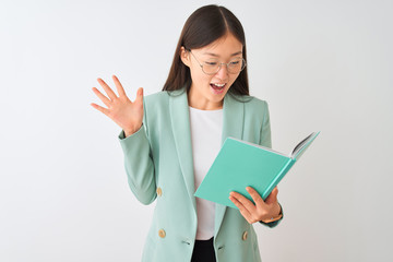 Sticker - Young chinese student woman wearing glasses reading book over isolated white background very happy and excited, winner expression celebrating victory screaming with big smile and raised hands